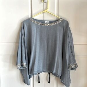 Super fun poncho like top with sequin detail.